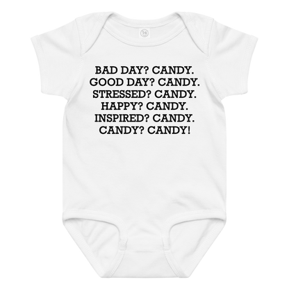 "Bad Day? Candy. Good Day? Candy. Stressed? Candy. Happy? Candy. Inspired? Candy. Candy? Candy!" printed on a white baby jersey bodysuit laying on a flat surface amongst other clothes