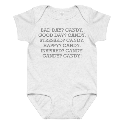 "Bad Day? Candy. Good Day? Candy. Stressed? Candy. Happy? Candy. Inspired? Candy. Candy? Candy!" printed on a ash baby jersey bodysuit laying on a flat surface amongst other clothes