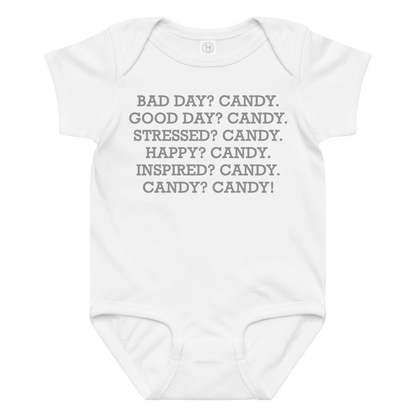 "Bad Day? Candy. Good Day? Candy. Stressed? Candy. Happy? Candy. Inspired? Candy. Candy? Candy!" printed on a white baby jersey bodysuit laying on a flat surface amongst other clothes