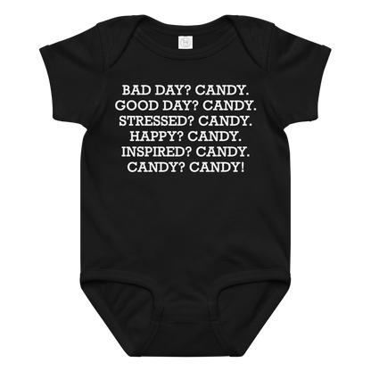 "Bad Day? Candy. Good Day? Candy. Stressed? Candy. Happy? Candy. Inspired? Candy. Candy? Candy!" printed on a black baby jersey bodysuit laying on a flat surface amongst other clothes