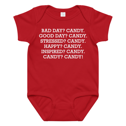 "Bad Day? Candy. Good Day? Candy. Stressed? Candy. Happy? Candy. Inspired? Candy. Candy? Candy!" printed on a red baby jersey bodysuit laying on a flat surface amongst other clothes