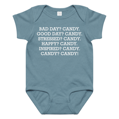 "Bad Day? Candy. Good Day? Candy. Stressed? Candy. Happy? Candy. Inspired? Candy. Candy? Candy!" printed on a vintage indigo baby jersey bodysuit laying on a flat surface amongst other clothes