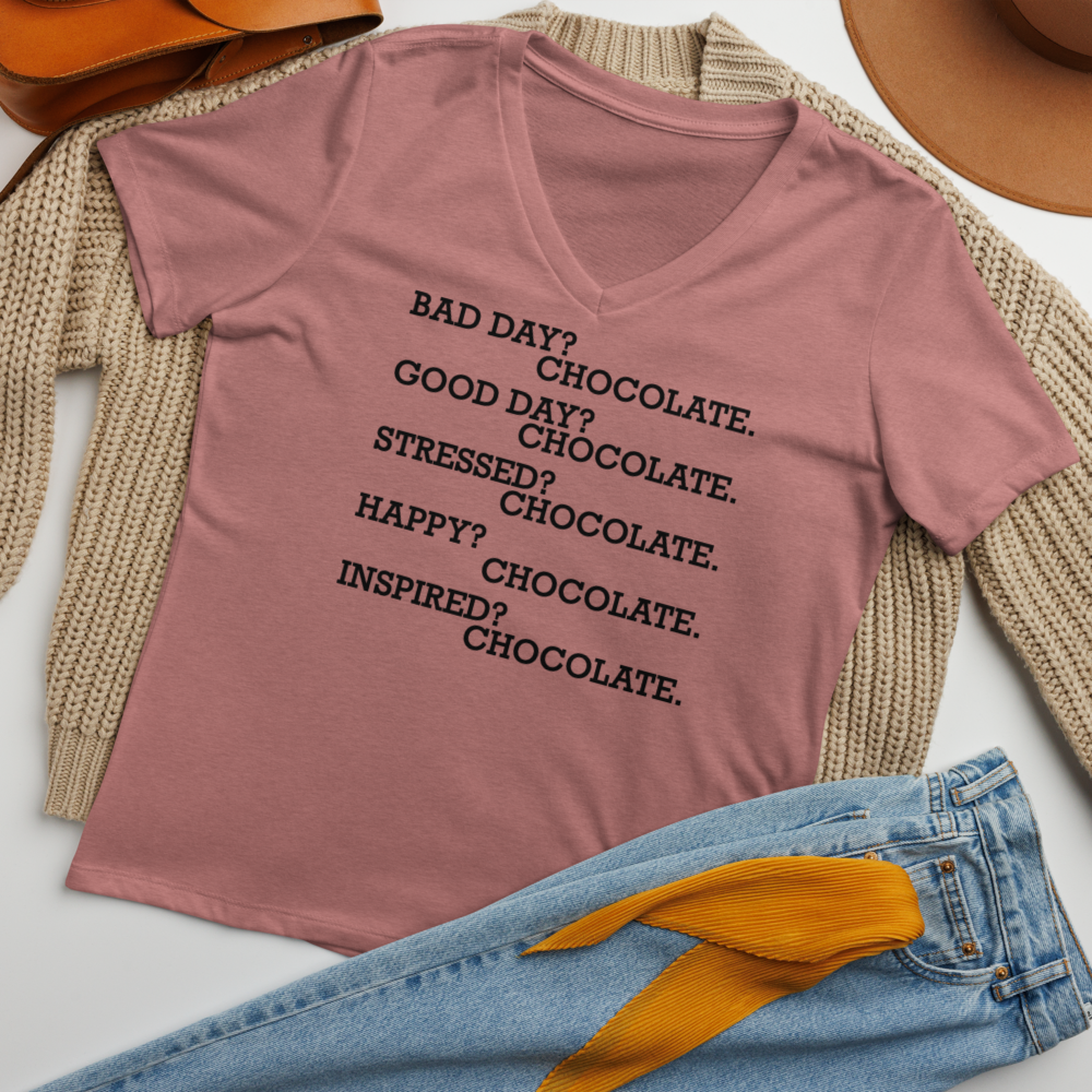 "Bad Day? Chocolate. Good Day? Chocolate. Stressed? Chocolate. Happy? Chocolate. Inspired? Chocolate. Chocolate? Chocolate!" printed on a heather mauve women's relaxed v-neck t-shirt laying on a flat surface amongst other clothes