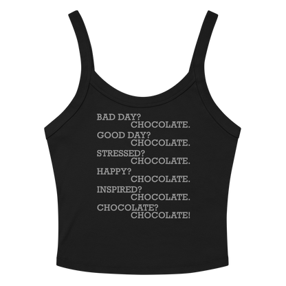 "Bad Day? Chocolate. Good Day? Chocolate. Stressed? Chocolate. Happy? Chocolate. Inspired? Chocolate. Chocolate? Chocolate!" printed on a solid black blend women's micro-rib tanktop laying on a flat surface amongst sunglasses and shorts