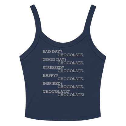 "Bad Day? Chocolate. Good Day? Chocolate. Stressed? Chocolate. Happy? Chocolate. Inspired? Chocolate. Chocolate? Chocolate!" printed on a solid navy blend women's micro-rib tanktop laying on a flat surface amongst sunglasses and shorts