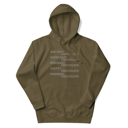 "Bad Day? Chocolate. Good Day? Chocolate. Stressed? Chocolate. Happy? Chocolate. Inspired? Chocolate. Chocolate? Chocolate!" printed on a military green unisex hoodie laying on a flat surface with the hood up