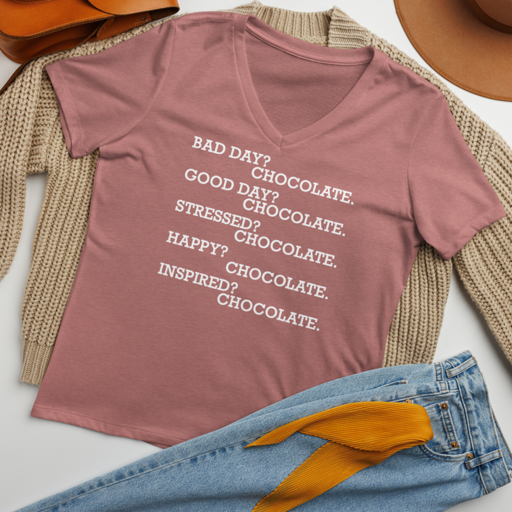 "Bad Day? Chocolate. Good Day? Chocolate. Stressed? Chocolate. Happy? Chocolate. Inspired? Chocolate. Chocolate? Chocolate!" printed on a heather mauve women's relaxed v-neck t-shirt laying on a flat surface amongst other clothes