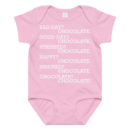 "Bad Day? Chocolate. Good Day? Chocolate. Stressed? Chocolate. Happy? Chocolate. Inspired? Chocolate. Chocolate? Chocolate!" printed on a pink baby jersey bodysuit laying on a flat surface amongst other clothes