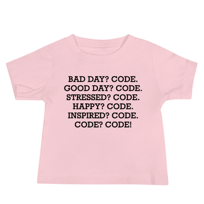 "Bad Day? Code. Good Day? Code. Stressed? Code. Happy? Code. Inspired? Code. Code? Code!" printed on a pink baby jersey short sleeve tee laying on a flat surface