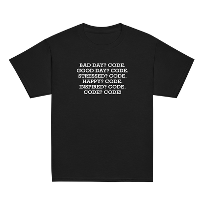 "Bad Day? Code. Good Day? Code. Stressed? Code. Happy? Code. Inspired? Code. Code? Code!" printed on a black youth classic tee laying on a flat surface