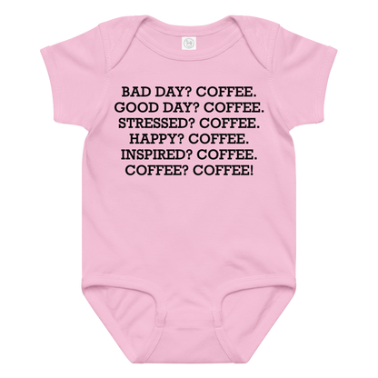 "Bad Day? Coffee. Good Day? Coffee. Stressed? Coffee. Happy? Coffee. Inspired? Coffee. Coffee? Coffee!" printed on a pink baby jersey bodysuit laying on a flat surface amongst other clothes