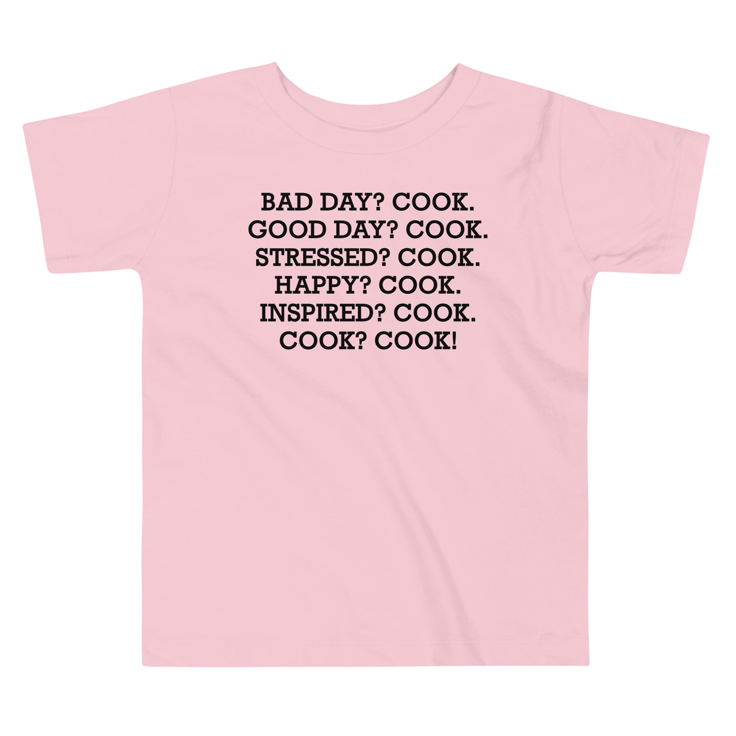 "Bad Day? Cook. Good Day? Cook. Stressed? Cook. Happy? Cook. Inspired? Cook. Cook? Cook!" printed on a pink toddler short sleeve tee laying on a flat surface