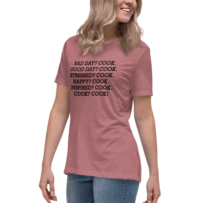 "Bad Day? Cook. Good Day? Cook. Stressed? Cook. Happy? Cook. Inspired? Cook. Cook? Cook!" printed on a heather mauve women's relaxed t-shirt worn by a female