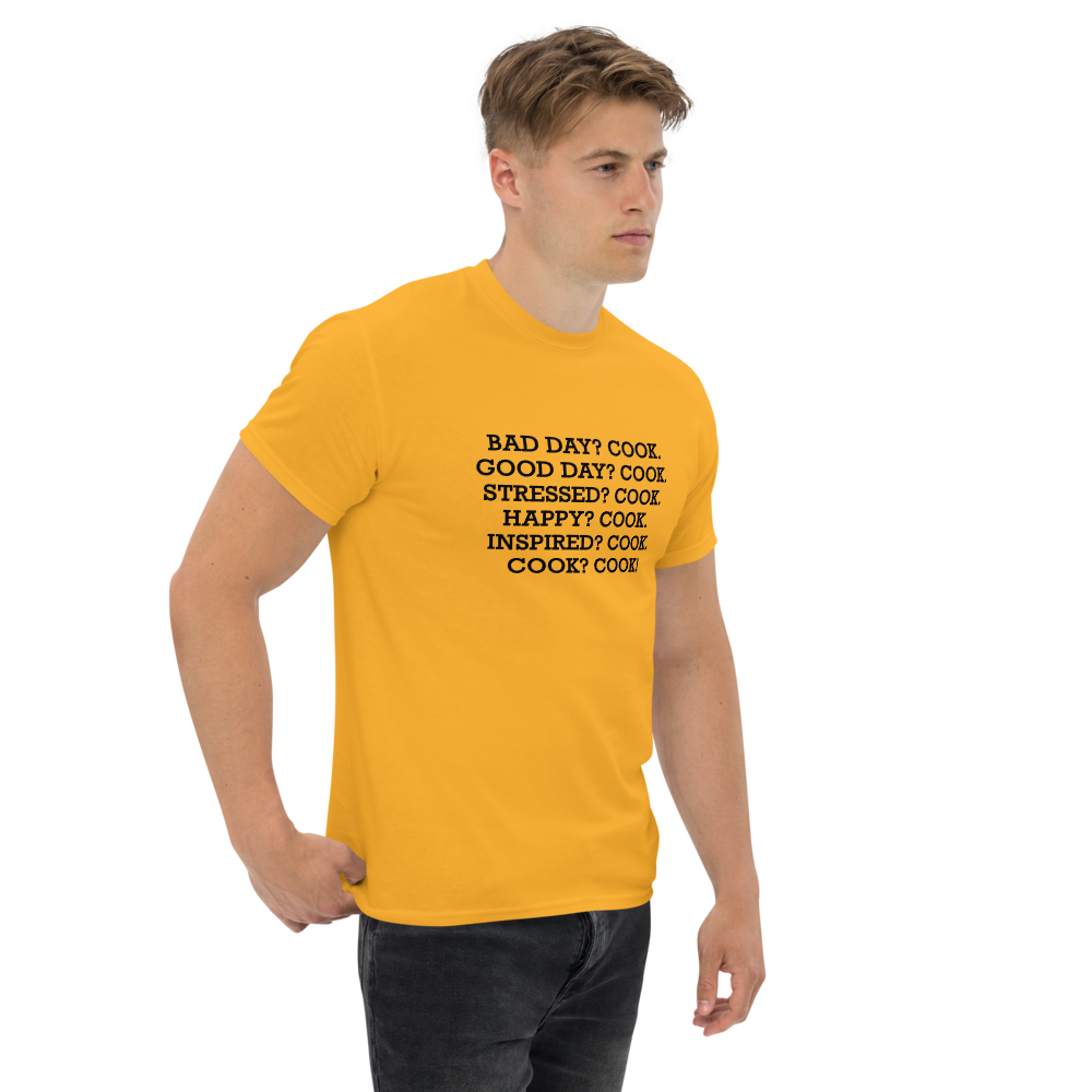 "Bad Day? Cook. Good Day? Cook. Stressed? Cook. Happy? Cook. Inspired? Cook. Cook? Cook!" printed on a gold unisex classic tee worn by a male