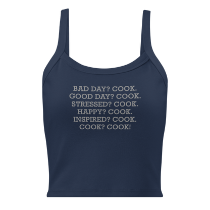 "Bad Day? Cook. Good Day? Cook. Stressed? Cook. Happy? Cook. Inspired? Cook. Cook? Cook!" printed on a solid navy blend women's micro-rib tanktop laying on a flat surface