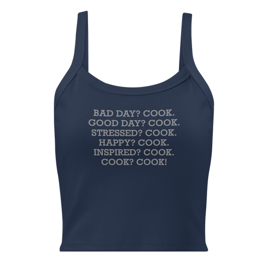 "Bad Day? Cook. Good Day? Cook. Stressed? Cook. Happy? Cook. Inspired? Cook. Cook? Cook!" printed on a solid navy blend women's micro-rib tanktop laying on a flat surface