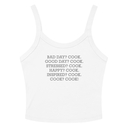 "Bad Day? Cook. Good Day? Cook. Stressed? Cook. Happy? Cook. Inspired? Cook. Cook? Cook!" printed on a solid white blend women's micro-rib tanktop laying on a flat surface amongst sunglasses and shorts