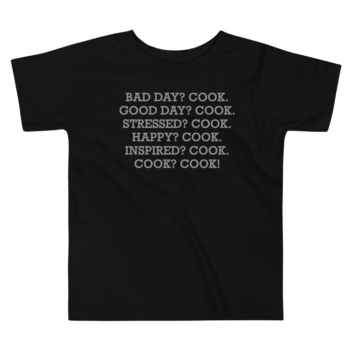 "Bad Day? Cook. Good Day? Cook. Stressed? Cook. Happy? Cook. Inspired? Cook. Cook? Cook!" printed on a black toddler short sleeve tee laying on a flat surface