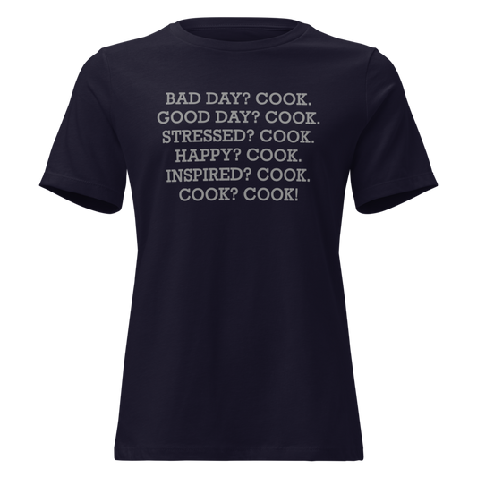 "Bad Day? Cook. Good Day? Cook. Stressed? Cook. Happy? Cook. Inspired? Cook. Cook? Cook!" printed on a navy on an invisible / simulated body