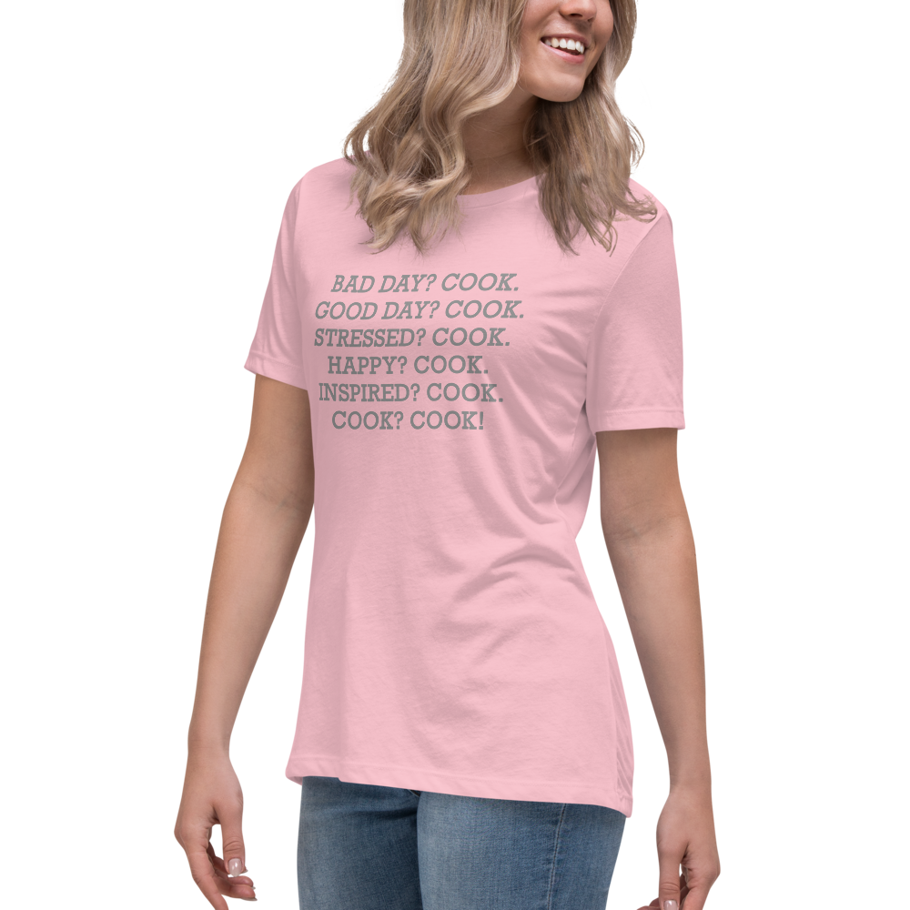 "Bad Day? Cook. Good Day? Cook. Stressed? Cook. Happy? Cook. Inspired? Cook. Cook? Cook!" printed on a pink women's relaxed t-shirt worn by a female