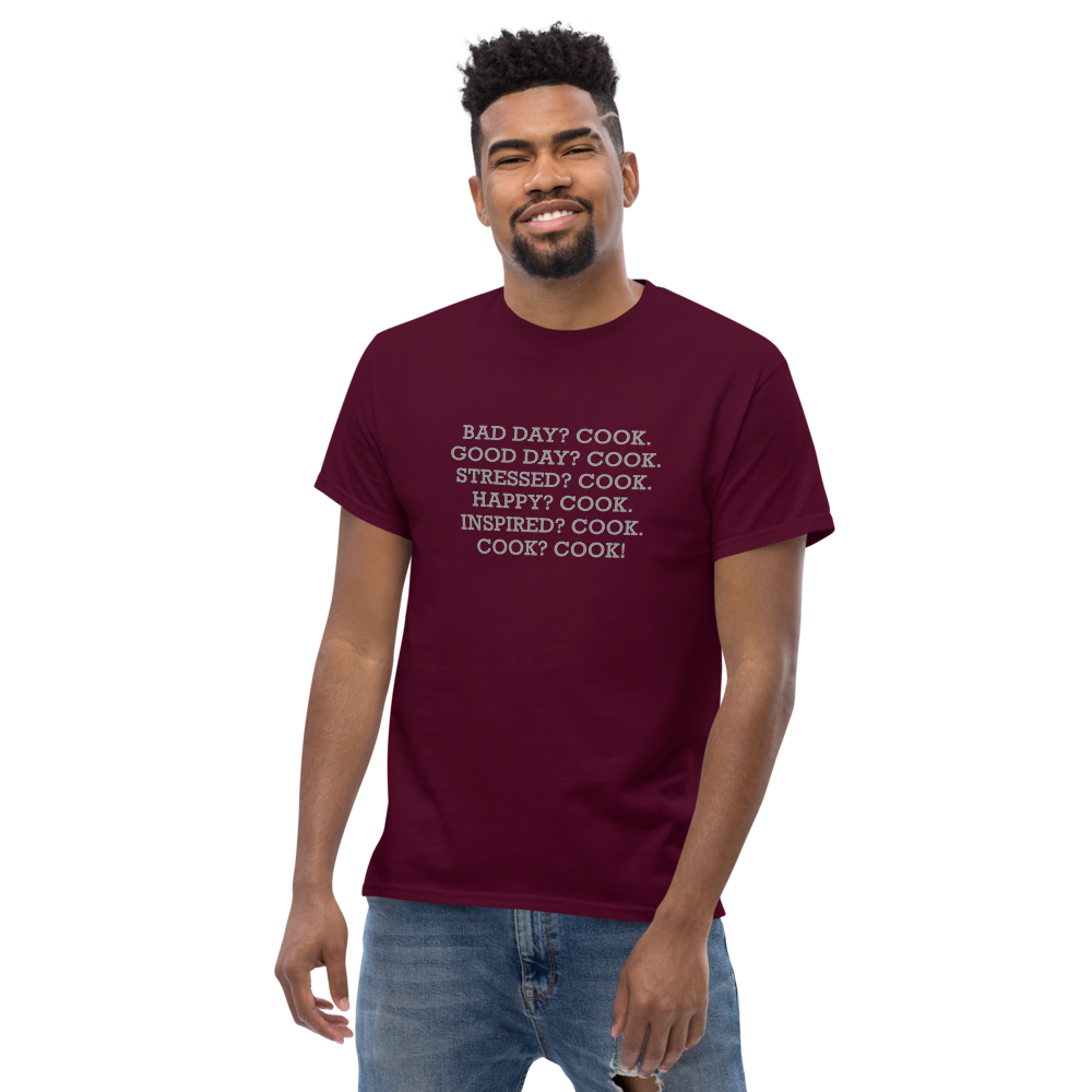 "Bad Day? Cook. Good Day? Cook. Stressed? Cook. Happy? Cook. Inspired? Cook. Cook? Cook!" printed on a maroon unisex classic tee worn by a male