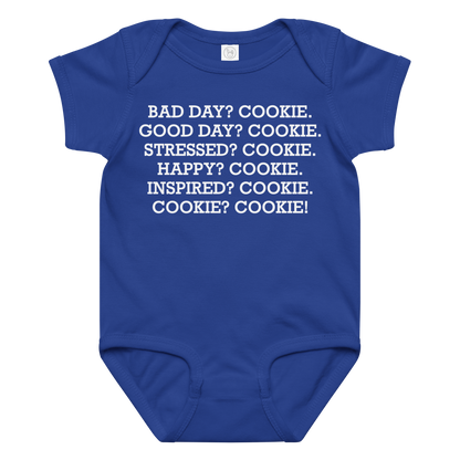 "Bad Day? Cook. Good Day? Cook. Stressed? Cook. Happy? Cook. Inspired? Cook. Cook? Cook!" printed on a royal baby jersey bodysuit laying on a flat surface amongst other clothes