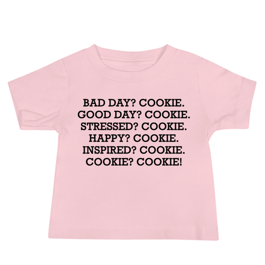 "Bad Day? Cookie. Good Day? Cookie. Stressed? Cookie. Happy? Cookie. Inspired? Cookie. Cookie? Cookie!" printed on a pink baby jersey short sleeve tee laying on a flat surface