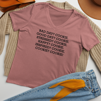 "Bad Day? Cookie. Good Day? Cookie. Stressed? Cookie. Happy? Cookie. Inspired? Cookie. Cookie? Cookie!" printed on a heather mauve women's relaxed v-neck t-shirt laying on a flat surface amongst other clothes