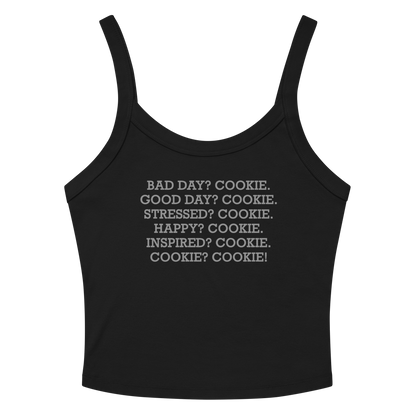 "Bad Day? Cookie. Good Day? Cookie. Stressed? Cookie. Happy? Cookie. Inspired? Cookie. Cookie? Cookie!" printed on a solid black blend women's micro-rib tanktop laying on a flat surface amongst sunglasses and shorts