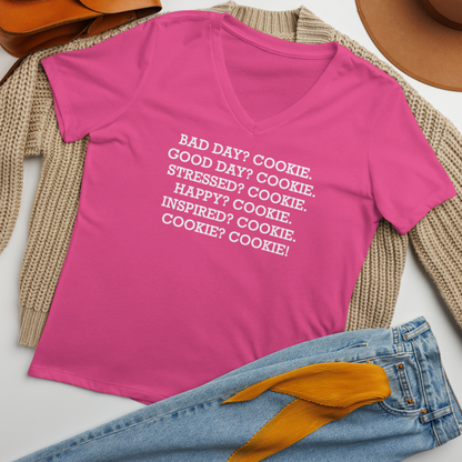 "Bad Day? Cookie. Good Day? Cookie. Stressed? Cookie. Happy? Cookie. Inspired? Cookie. Cookie? Cookie!" printed on a berry women's relaxed v-neck t-shirt laying on a flat surface amongst other clothes