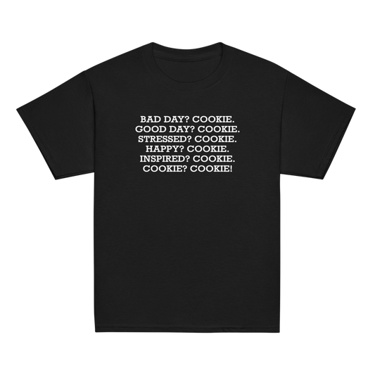 "Bad Day? Cookie. Good Day? Cookie. Stressed? Cookie. Happy? Cookie. Inspired? Cookie. Cookie? Cookie!" printed on a black youth classic tee laying on a flat surface