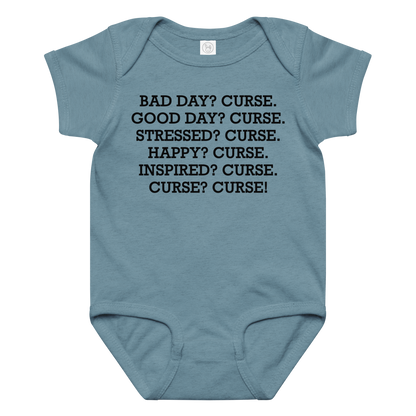 "Bad Day? Curse. Good Day? Curse. Stressed? Curse. Happy? Curse. Inspired? Curse. Curse? Curse!" printed on a vintage indigo baby jersey bodysuit laying on a flat surface amongst other clothes