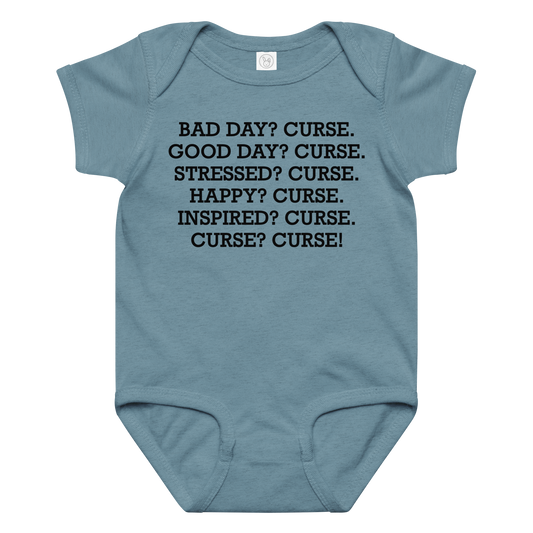 "Bad Day? Curse. Good Day? Curse. Stressed? Curse. Happy? Curse. Inspired? Curse. Curse? Curse!" printed on a vintage indigo baby jersey bodysuit laying on a flat surface amongst other clothes