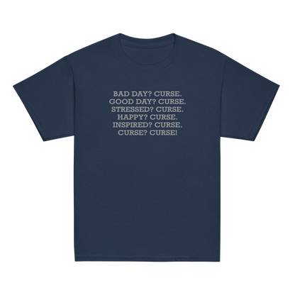 "Bad Day? Curse. Good Day? Curse. Stressed? Curse. Happy? Curse. Inspired? Curse. Curse? Curse!" printed on a navy youth classic tee laying on a flat surface