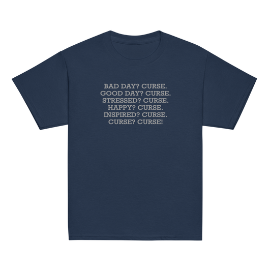 "Bad Day? Curse. Good Day? Curse. Stressed? Curse. Happy? Curse. Inspired? Curse. Curse? Curse!" printed on a navy youth classic tee laying on a flat surface
