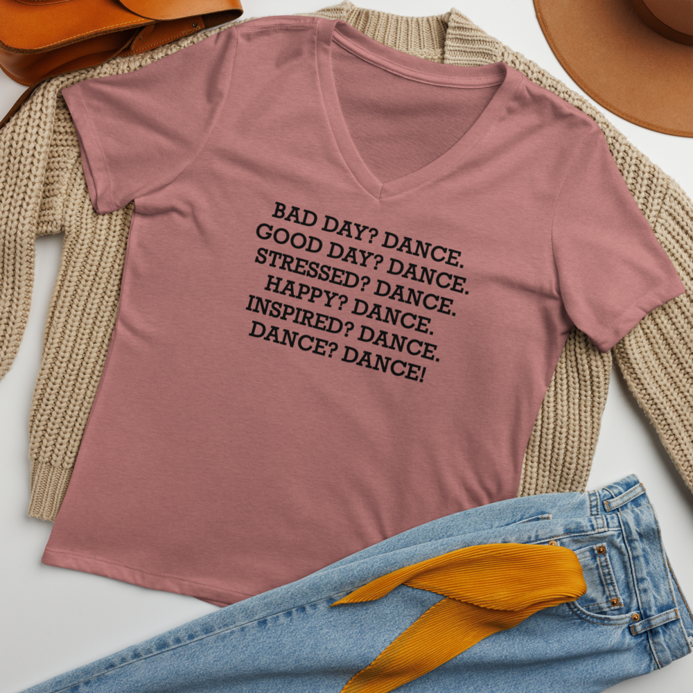 "Bad Day? Dance. Good Day? Dance. Stressed? Dance. Happy? Dance. Inspired? Dance. Dance? Dance!" printed on a heather mauve women's relaxed v-neck t-shirt laying on a flat surface amongst other clothes