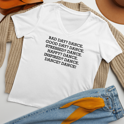 "Bad Day? Dance. Good Day? Dance. Stressed? Dance. Happy? Dance. Inspired? Dance. Dance? Dance!" printed on a solid white blend women's relaxed v-neck t-shirt laying on a flat surface amongst other clothes