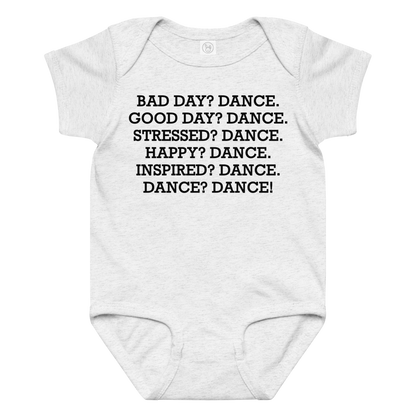 "Bad Day? Dance. Good Day? Dance. Stressed? Dance. Happy? Dance. Inspired? Dance. Dance? Dance!" printed on a ash baby jersey bodysuit laying on a flat surface amongst other clothes