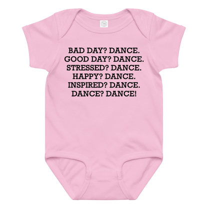 "Bad Day? Dance. Good Day? Dance. Stressed? Dance. Happy? Dance. Inspired? Dance. Dance? Dance!" printed on a pink baby jersey bodysuit laying on a flat surface amongst other clothes