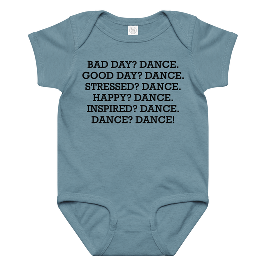 "Bad Day? Dance. Good Day? Dance. Stressed? Dance. Happy? Dance. Inspired? Dance. Dance? Dance!" printed on a vintage indigo baby jersey bodysuit laying on a flat surface amongst other clothes
