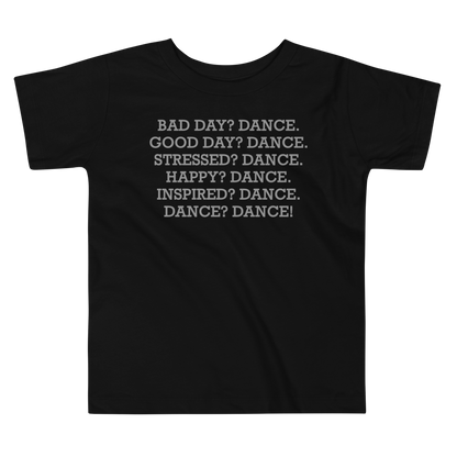 "Bad Day? Dance. Good Day? Dance. Stressed? Dance. Happy? Dance. Inspired? Dance. Dance? Dance!" printed on a black toddler short sleeve tee laying on a flat surface