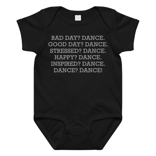 "Bad Day? Dance. Good Day? Dance. Stressed? Dance. Happy? Dance. Inspired? Dance. Dance? Dance!" printed on a black baby jersey bodysuit laying on a flat surface amongst other clothes