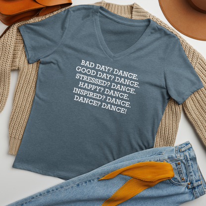 "Bad Day? Dance. Good Day? Dance. Stressed? Dance. Happy? Dance. Inspired? Dance. Dance? Dance!" printed on a heather slate women's relaxed v-neck t-shirt laying on a flat surface amongst other clothes