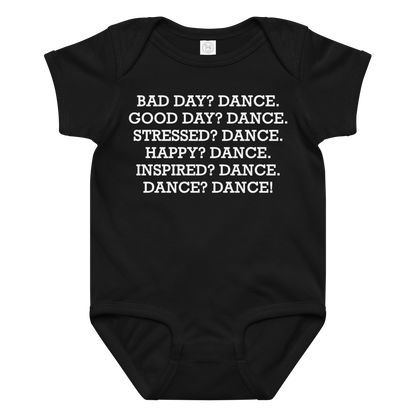 "Bad Day? Dance. Good Day? Dance. Stressed? Dance. Happy? Dance. Inspired? Dance. Dance? Dance!" printed on a black baby jersey bodysuit laying on a flat surface amongst other clothes