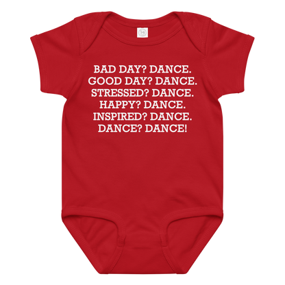 "Bad Day? Dance. Good Day? Dance. Stressed? Dance. Happy? Dance. Inspired? Dance. Dance? Dance!" printed on a red baby jersey bodysuit laying on a flat surface amongst other clothes