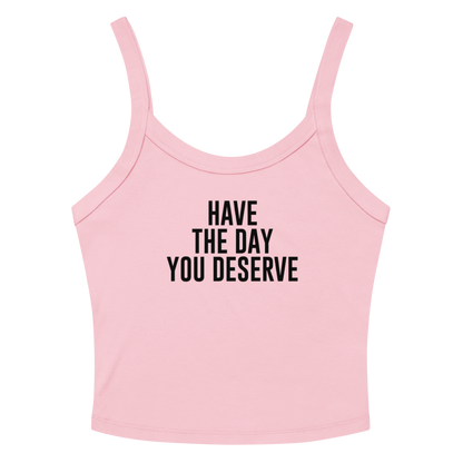"Have the day you deserve" printed on a solid pink blend women's micro-rib tanktop laying on a flat surface amongst sunglasses and shorts