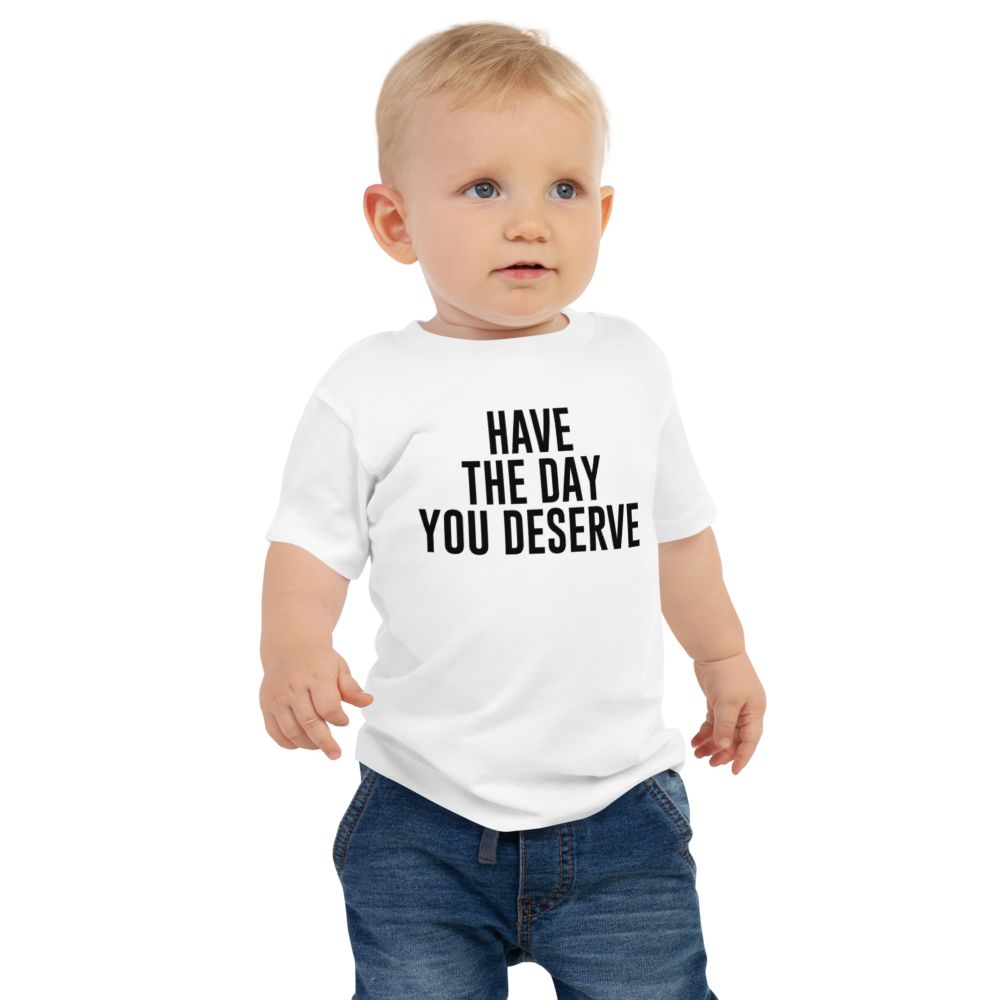 "Have the day you deserve" printed on a white baby jersey short sleeve tee worn by a male