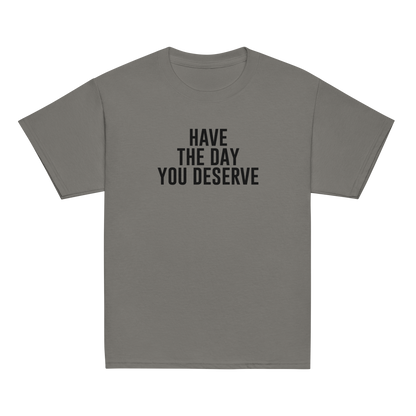 "Have the day you deserve" printed on a charcoal youth classic tee laying on a flat surface