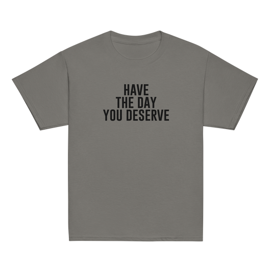 "Have the day you deserve" printed on a charcoal youth classic tee laying on a flat surface