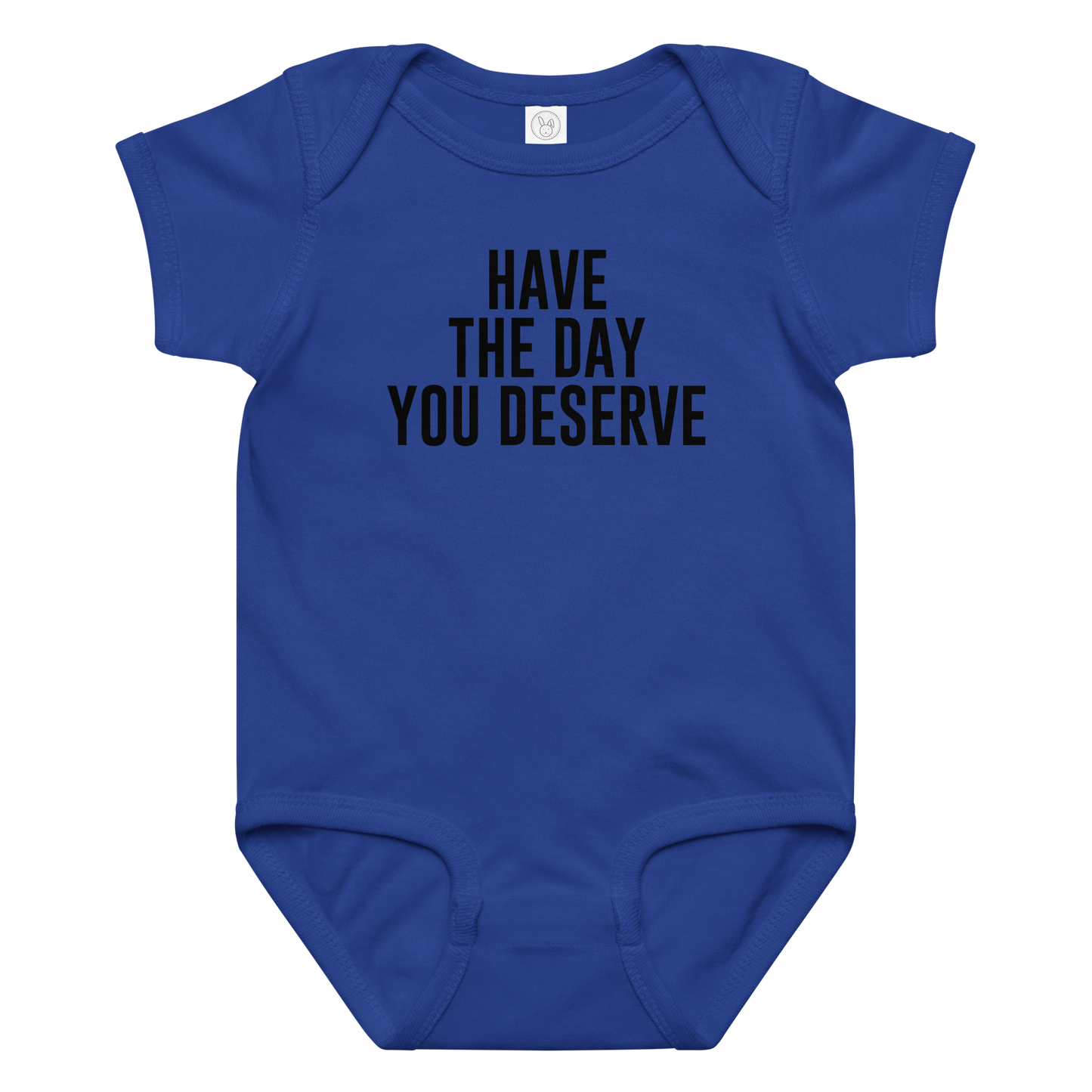 "Have the day you deserve" printed on a royal baby jersey bodysuit laying on a flat surface amongst other clothes